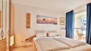 Ein Schlafzimmer mit einem großen Bett, einem Holzschrank und einem Bild an der Wand.