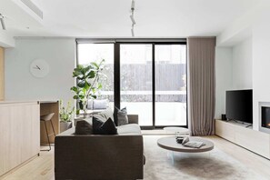 A modern living room with a sofa, coffee table, and a TV.