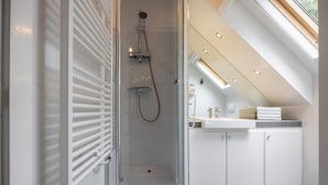 A modern bathroom with a glass-enclosed shower, white cabinetry, and a skylight. - Studio in Kamperland With Terrace (Kamperland)