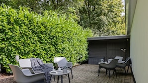 An outdoor patio area with modern seating and a hedge in the background. - Studio in Kamperland With Terrace (Kamperland)