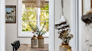 A dining area with a window, a hanging light fixture, and a vintage ice skates display. - Lola Cottage - Your Charming Retreat in the Heart of Adaminaby (Adaminaby)