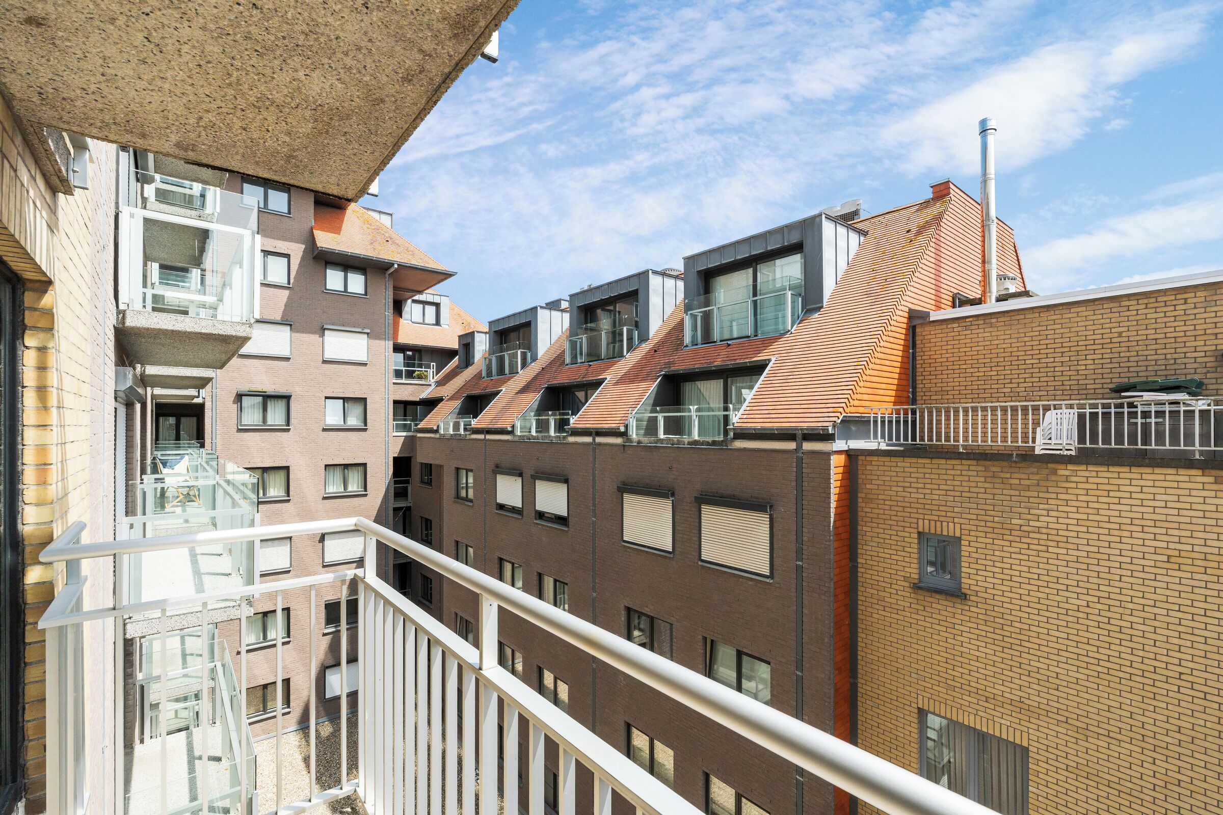 Un edificio residencial de varios pisos con un estilo arquitectónico moderno, que cuenta con balcones y grandes ventanales.