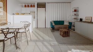 A modern living room with a dining area, a sofa, a coffee table, and a striped rug. - 1 bedroom accommodation in NIEUWPOORT (NIEUWPOORT)