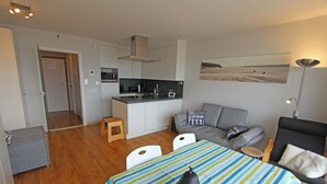 A compact living space with a kitchenette, a dining area, and a seating area.
