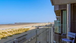 Ein Balkon mit Blick auf einen Strand und einen Steg.