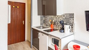 A compact kitchen with a sink, a coffee maker, and a red bowl on a table. - Modern and cozy studio at the chairlift's base (Saint-François-Longchamp)