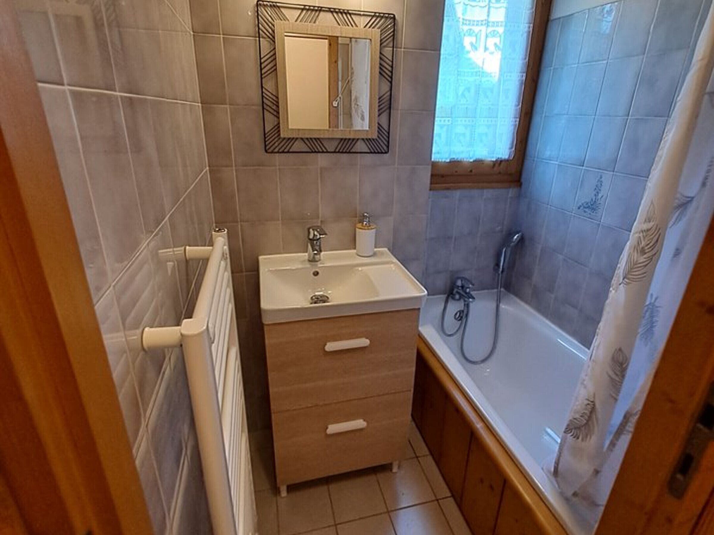 Une salle de bain avec un lavabo, un miroir et une douche.