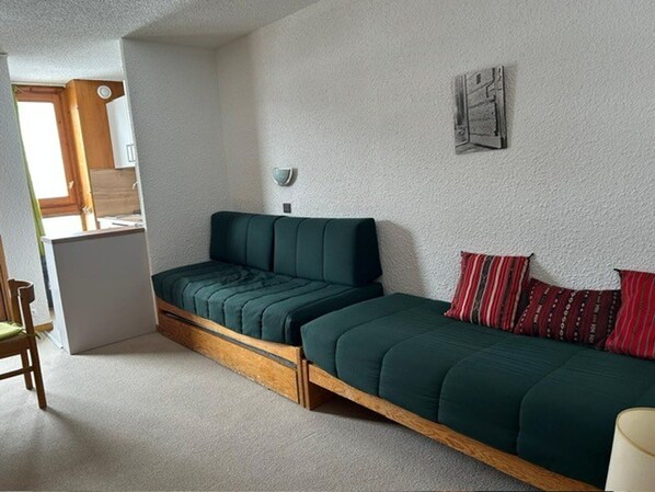 A compact room with a bed, a chair, and a small table.