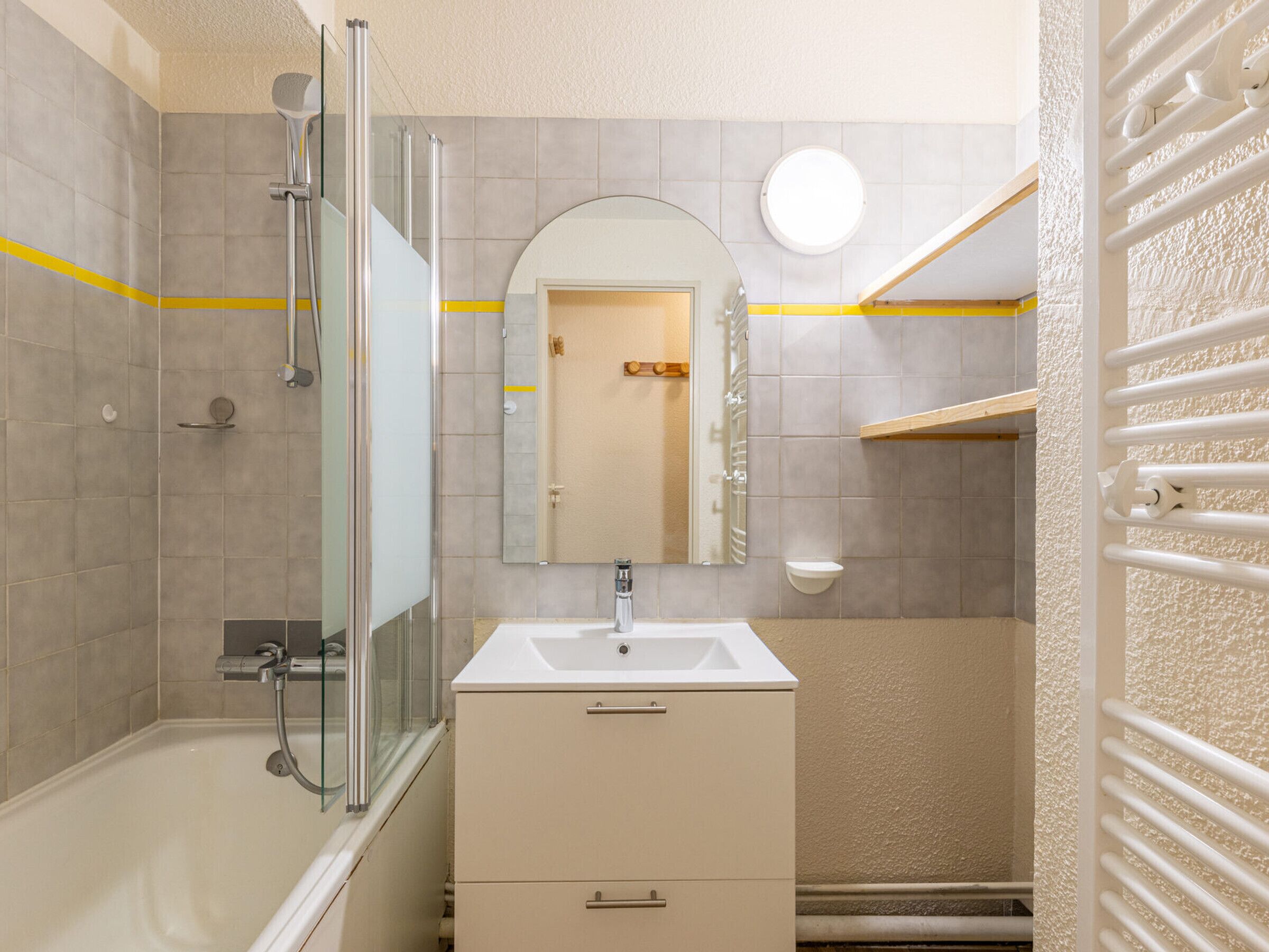A bathroom with a bathtub, a glass-enclosed shower, a sink, and a mirror.