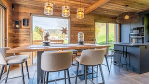Una cocina moderna con una isla grande, taburetes de bar e iluminación colgante.