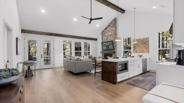 Una cocina moderna con chimenea de piedra, vigas de madera y una isla grande.