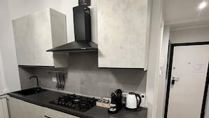 A modern kitchen with a built-in stove, sink, and a coffee maker. - Apartment Rome center (Roma)
