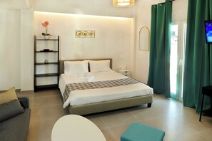 Une chambre d’hôtel moderne équipée d’un lit, d’un canapé, d’une petite table et d’un téléviseur.