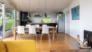 Una cocina moderna con comedor, ventanas amplias y chimenea.