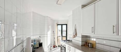 A modern kitchen with white cabinets, a granite countertop, and a stainless steel sink.
