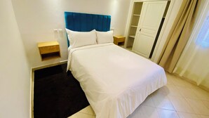 A hotel room with a bed, a nightstand, a wardrobe, and a bathroom. - Quiet modern apartment in Guéliz with parking and wifi (Marrakech)