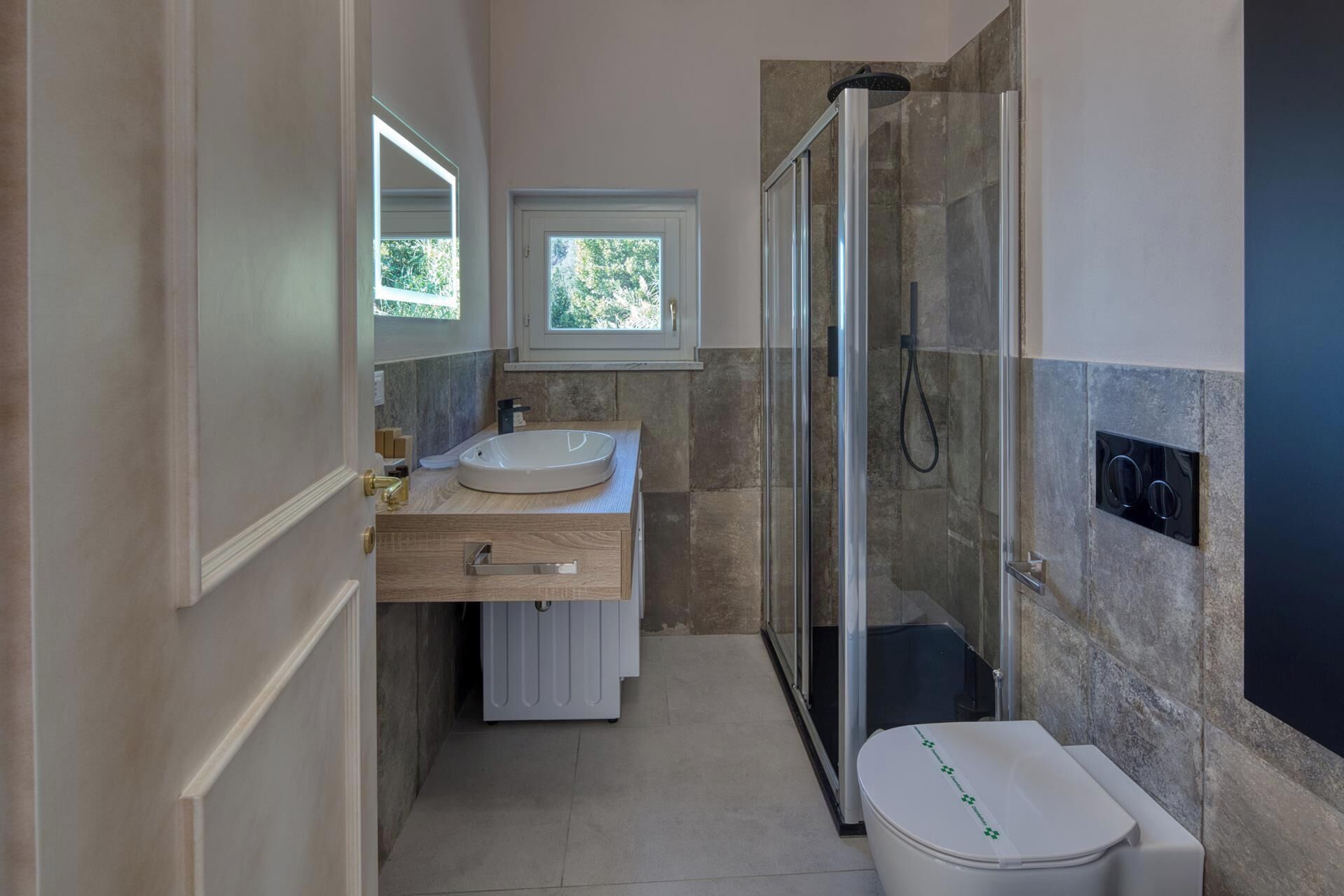 Une petite salle de bain comprenant une douche, un lavabo et des toilettes.