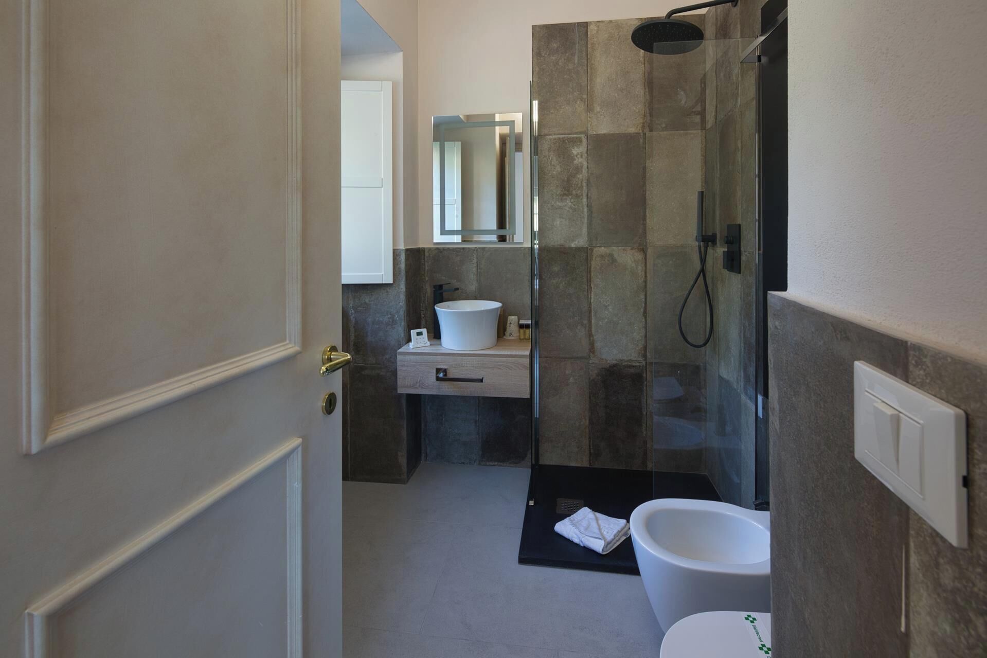 Et moderne badeværelse med bruser, toilet og vask.