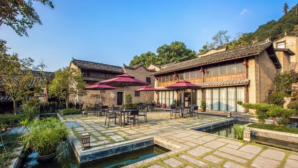 A courtyard with traditional architecture, stone flooring, and a small water feature. - ESGBihu Digital Nomad Cowork Colive Hub (Lishui)