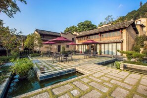 A courtyard with traditional architecture, stone flooring, and a small water feature. - ESGBihu Digital Nomad Cowork Colive Hub (Lishui)