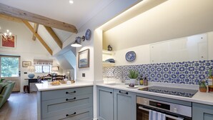 A modern kitchen with light blue cabinets, a white countertop, and a blue and white patterned backsplash.