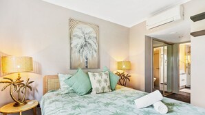 A hotel room with a bed, a painting, a lamp, and a mirror. - Coral Luxe Resort - 9 Pools Gym BBQ (Westcourt)