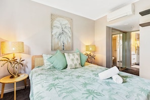 A hotel room with a bed, a painting, a lamp, and a mirror. - Coral Luxe Resort - 9 Pools Gym BBQ (Westcourt)
