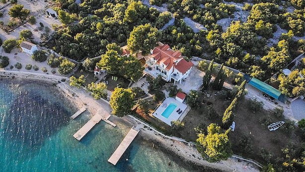 An aerial view of a coastal property with a swimming pool, multiple buildings, and a dock. - Nice apartment in Pirovac (Pirovac)