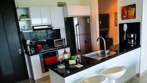 A modern kitchen with a stove, microwave, refrigerator, and sink. - Modern and Spacious Family Loft with Private Beach / Relax in Cartagena (Cartagena de Indias)