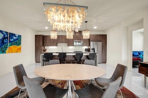 Cozinha moderna com armários de madeira escura, ilha central e lustre.