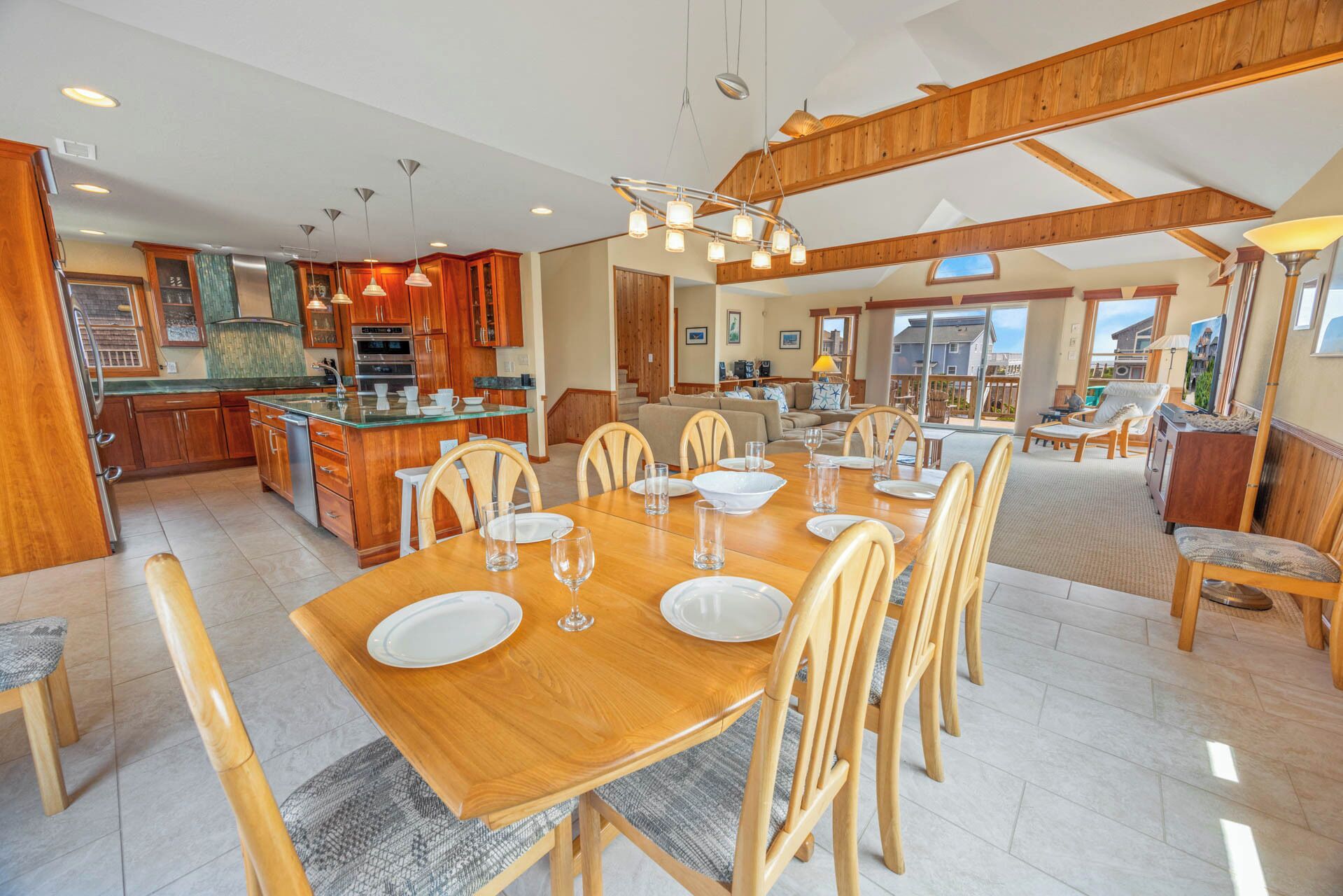 A spacious kitchen with wooden cabinets, a central island, and modern lighting.