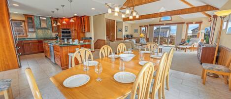 A spacious kitchen with wooden cabinets, a central island, and modern lighting.