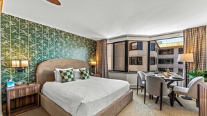 A hotel room with a large bed, a desk with a chair, and a view of the city through a large window. - Grand Lodge Studio 412 — Ski-In/Out Mt CB, Hot Tub & Pool, Pets OK (Crested Butte)