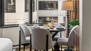 A dining area with a round table, four chairs, and a lamp. - Grand Lodge Studio 412 — Ski-In/Out Mt CB, Hot Tub & Pool, Pets OK (Crested Butte)