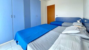Ein Schlafzimmer mit zwei Betten, einem Kleiderschrank und einer Tür.