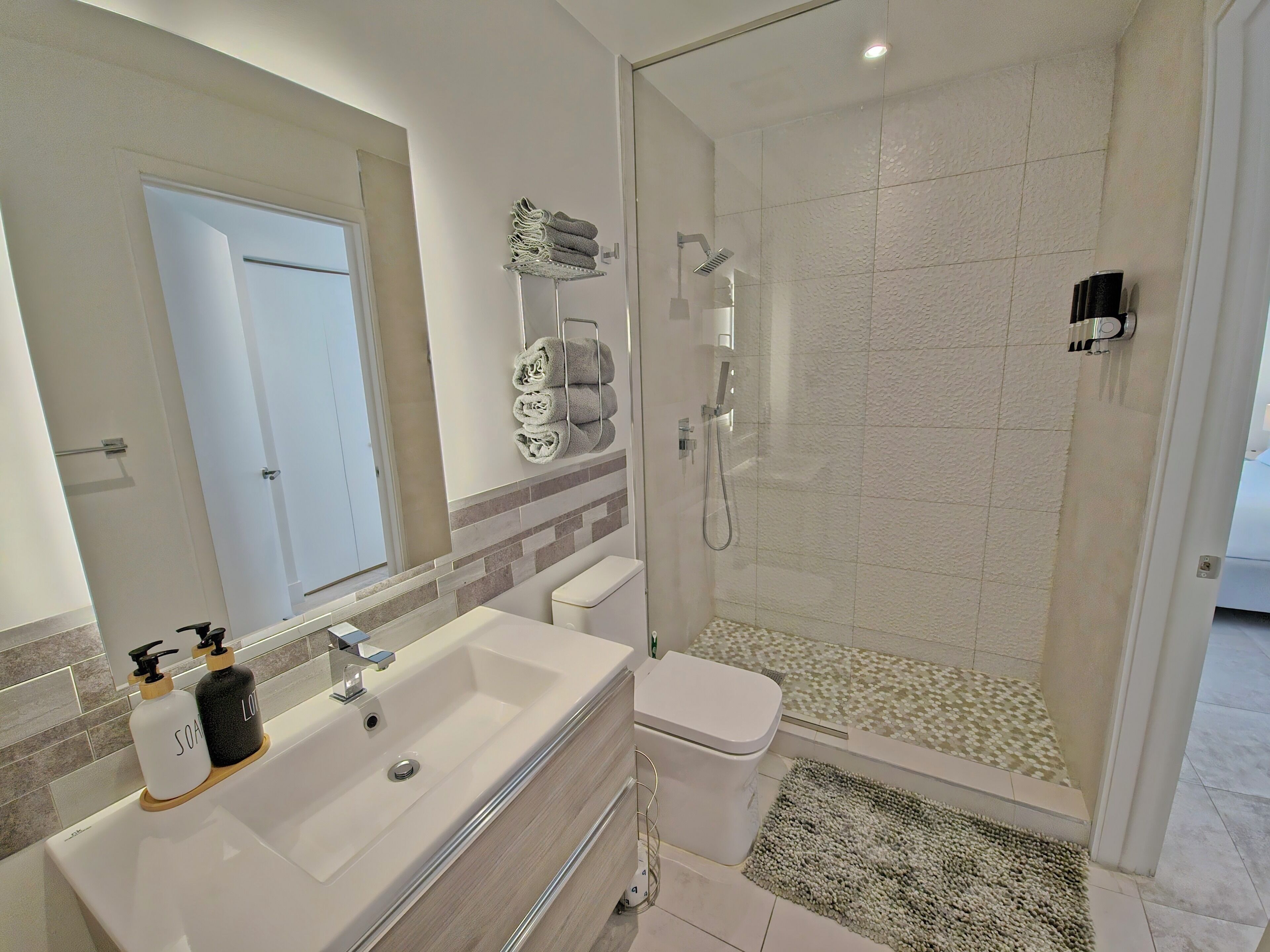 A modern bathroom with a sink, toilet, and shower.