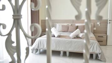 Un dormitorio ordenado con cama, almohadas y mesita de noche.