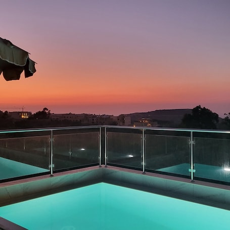 Una piscina al aire libre de temporada, sombrillas