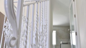 A white ornate metal gate leading into a room with a white interior and a visible sink in the background. - San Pawl bnb Farmhouse Calypso (Xaghra)
