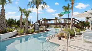 A pool area with a no diving sign, palm trees, and outdoor seating. - Brand New, Stylish Home 5B/4, 5B, Heated Pool & BBQ (Clermont)