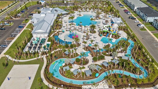 An aerial view of a resort with a large central pool, multiple smaller pools, and a water park. - Brand New, Stylish Home 5B/4, 5B, Heated Pool & BBQ (Clermont)