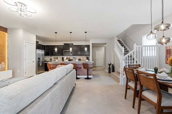 A modern kitchen with dark cabinets, a central island, and pendant lighting. - Brand New, Stylish Home 5B/4, 5B, Heated Pool & BBQ (Clermont)
