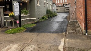 A narrow street with a building featuring a sign for 'Mercantile Parking in Back'.