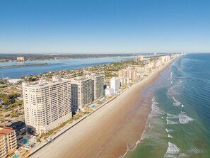 Eine Küstenstadt mit hohen Wolkenkratzern, einem Strand und einem Jachthafen.