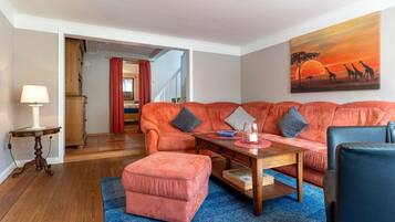 A living room with a sofa set, a coffee table, a lamp, and a painting on the wall.