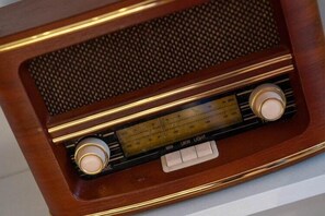 Une radio en bois, dotée d’une grille de haut-parleur et de boutons de réglage.