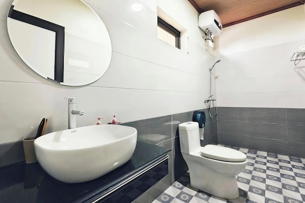 A modern bathroom with a large oval sink, a toilet, and a shower. - Hidden Valley Eco Retreat Trang An (Hoa Lu)