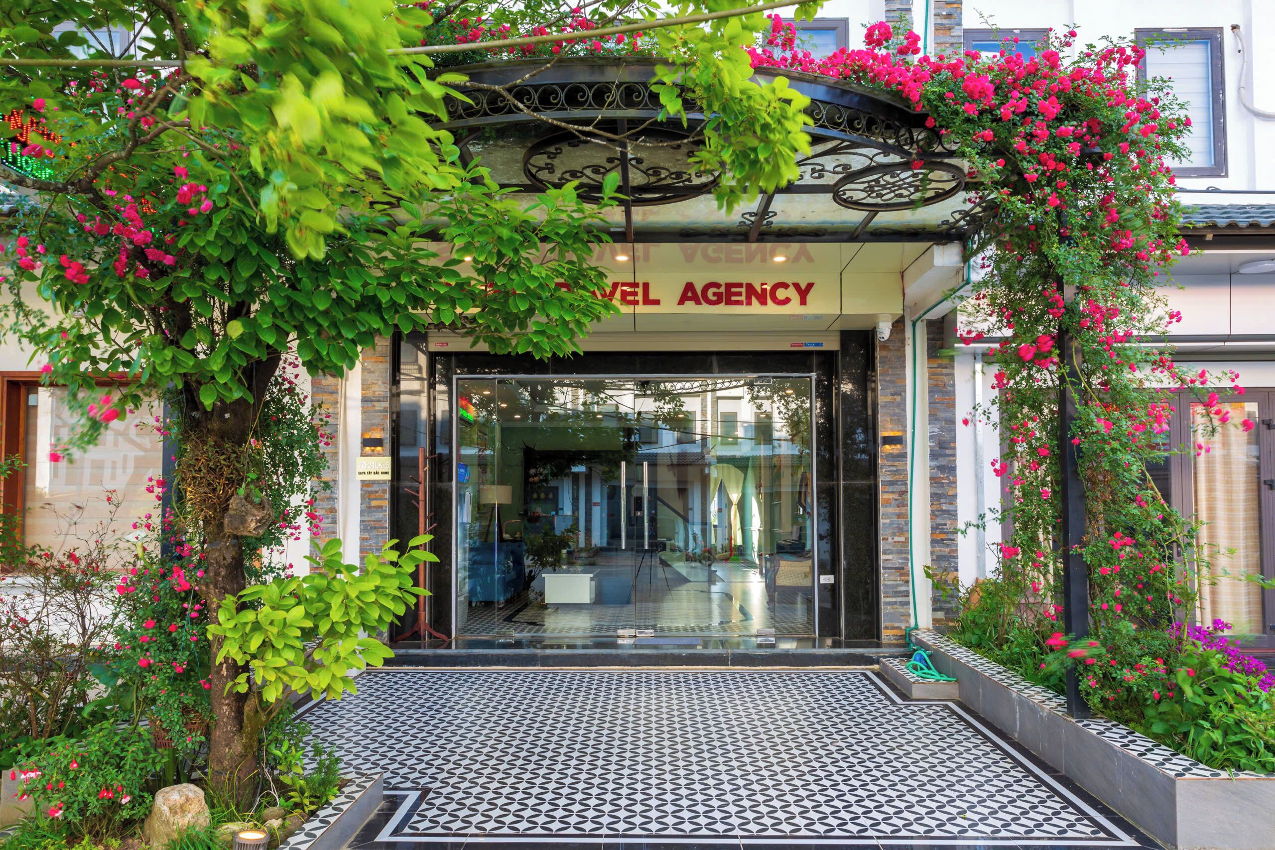 A hotel entrance with a tiled entrance, a glass door, and a sign that reads "HOTEL AGENCY".