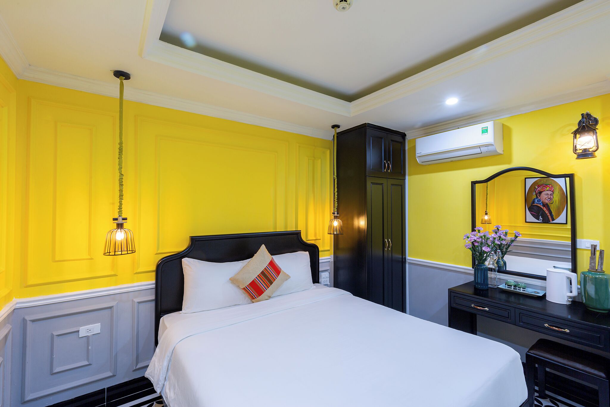 A hotel room with a bed, a nightstand, a dresser, and a mirror.
