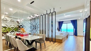 Een moderne hotelkamer met een zithoek, een bank en uitzicht op de oceaan.
